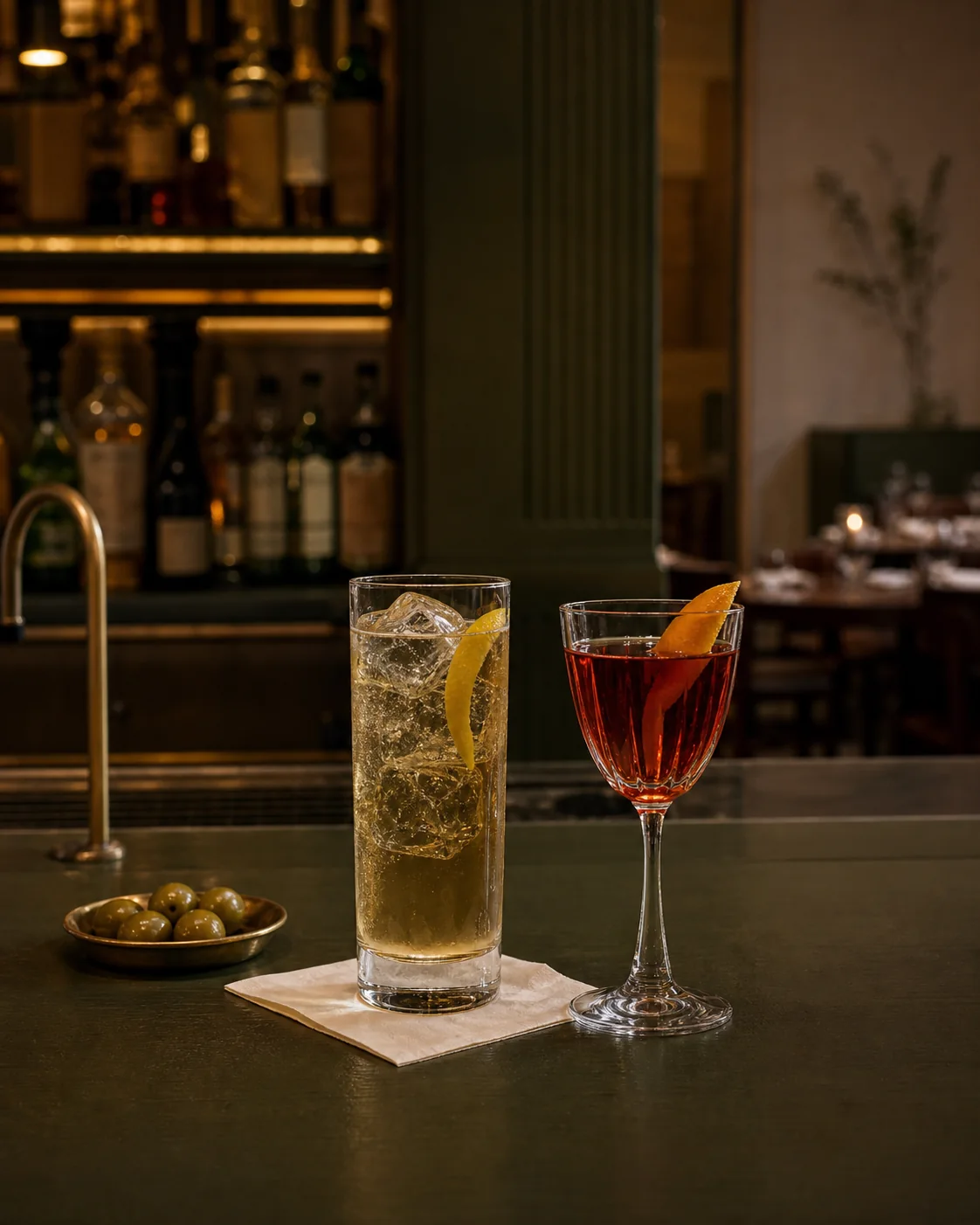 Two aperitifs on a dark green bar at the start of an Ealing date night